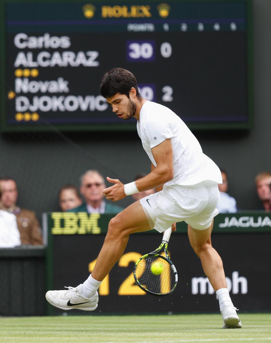 Carlos Alcaraz hits a tweener (between the legs shot with his back facing the net) against Novak Djokovic in the 2023 Wimbledon final. — Tennis and travel photos courtesy Juergen Hasenkopf