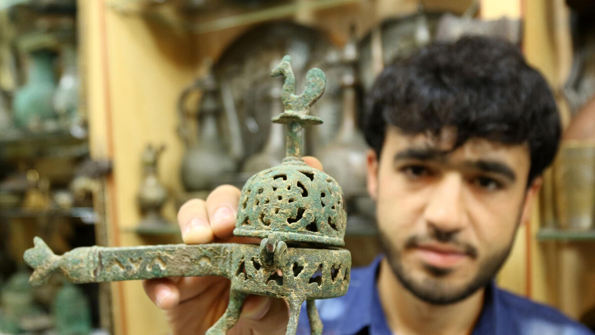 FRAGRANCE FROM THE PAST... Abdul Basir from Afghanistan shows off a 400-year-old Afghani oud stand at his antique shop.