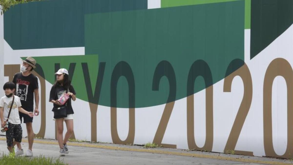 Pedestrians seen next to Tokyo 2020 Olympics posters in Tokyo on Wednesday. (AP)
