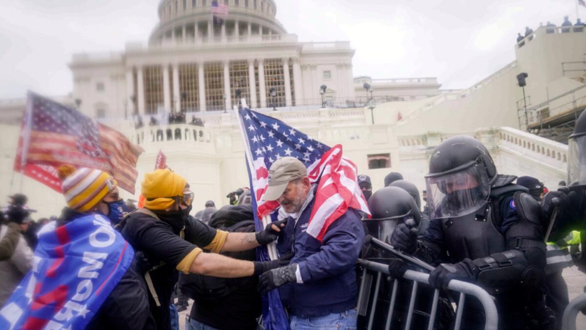 Rioters try to break through a police barrier at the Capitol in Washington on January 6. — AP