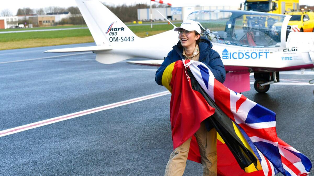 Zara Rutherford walks on the tarmac with a British and Belgian flag after landing her Shark ultralight plane at the Kortrijk airport in Kortrijk, Belgium. – AP