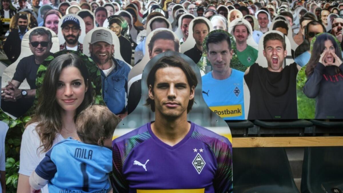 Gladbach goalkeeper Yann Sommer is pictured next to his partner Alina among the cardboard cut-out supporters for Saturday's game at home to Leverkusen. - AFP
