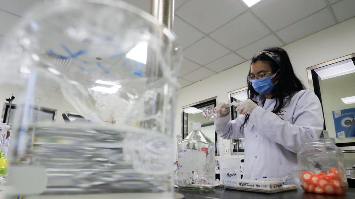 A pharmacist doctor works on the basics of the raw materials for investigational of the coronavirus disease (Covid-19) treatment drug 'Remdesivir', in Ibn Sina laboratory, at Eva Pharma Facility in Cairo, Egypt. Photo: Reuters