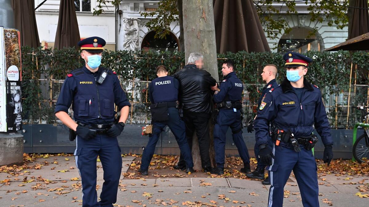 A man is detained by the police after he allegedly tried to cross the closed area repeatedly, in Vienna, on November 03, 2020, after the multiple shootings leaving four people dead on the eve occurred in the Austrian capital.