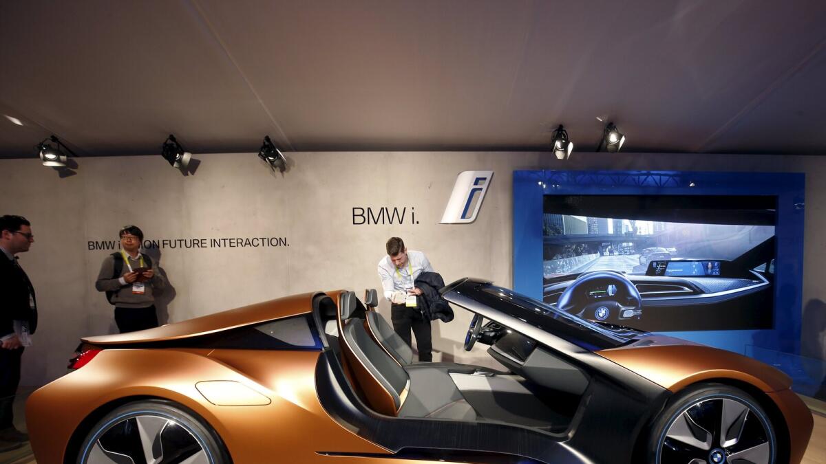 People look over the BMW i Vision Future Interaction concept car during the 2016 CES trade show in Las Vegas, Nevada. The car includes BMW AirTouch technology that lets the driver control various functions with simple gestures.