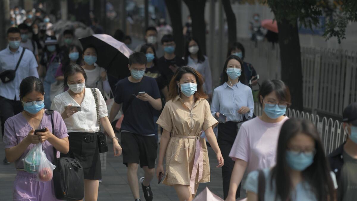 People wear masks as they walk to work in Beijing. Beijing has partially lifted weeks-long lockdown imposed in the Chinese capital to head off a feared second wave of coronavirus infections after three million samples were taken in two weeks, officials said. Dozens of residential compounds across the city were shut down, with authorities rolling out a mass testing campaign to root out any remaining cases.  Photo: AFP