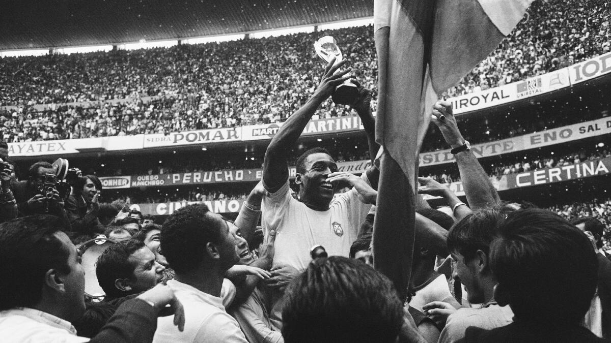 In this June 21, 1970 file photo, Brazil's Pele holds up his team's Jules Rimet Trophy, or the Fifa World Cup Trophy, following Brazil's 4-1 victory over Italy at the Azteca Stadium in Mexico City. - AP file
