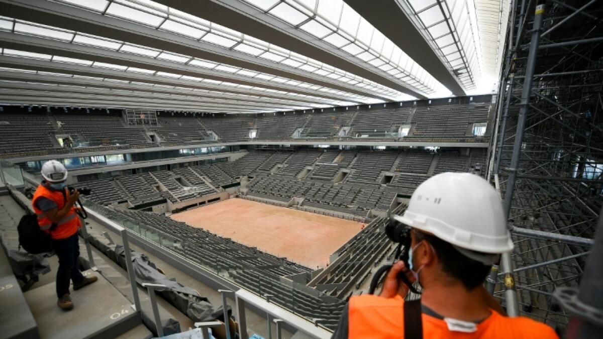 Visitors take pictures of the newly-built roof on the Philippe Chatrier court at Roland Garros. - AFP