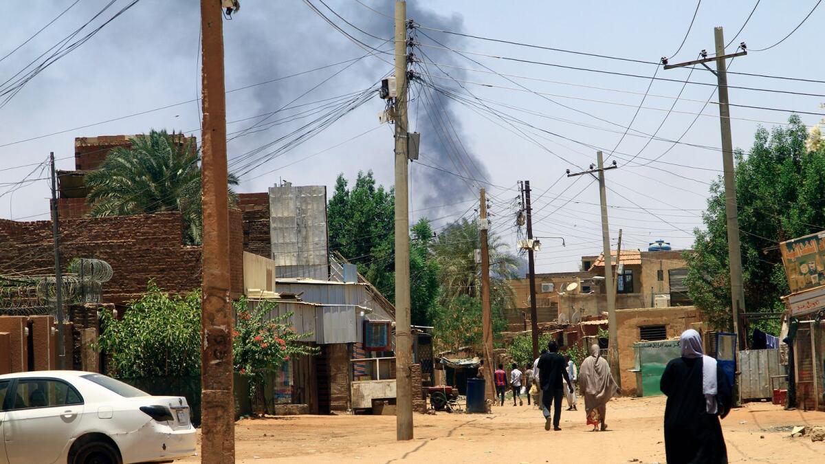 Smoke rises behind buildings in Khartoum on April 19, 2023, as fighting between the army and paramilitaries raged for a fifth day after a 24-hour truce collapsed. - AFP