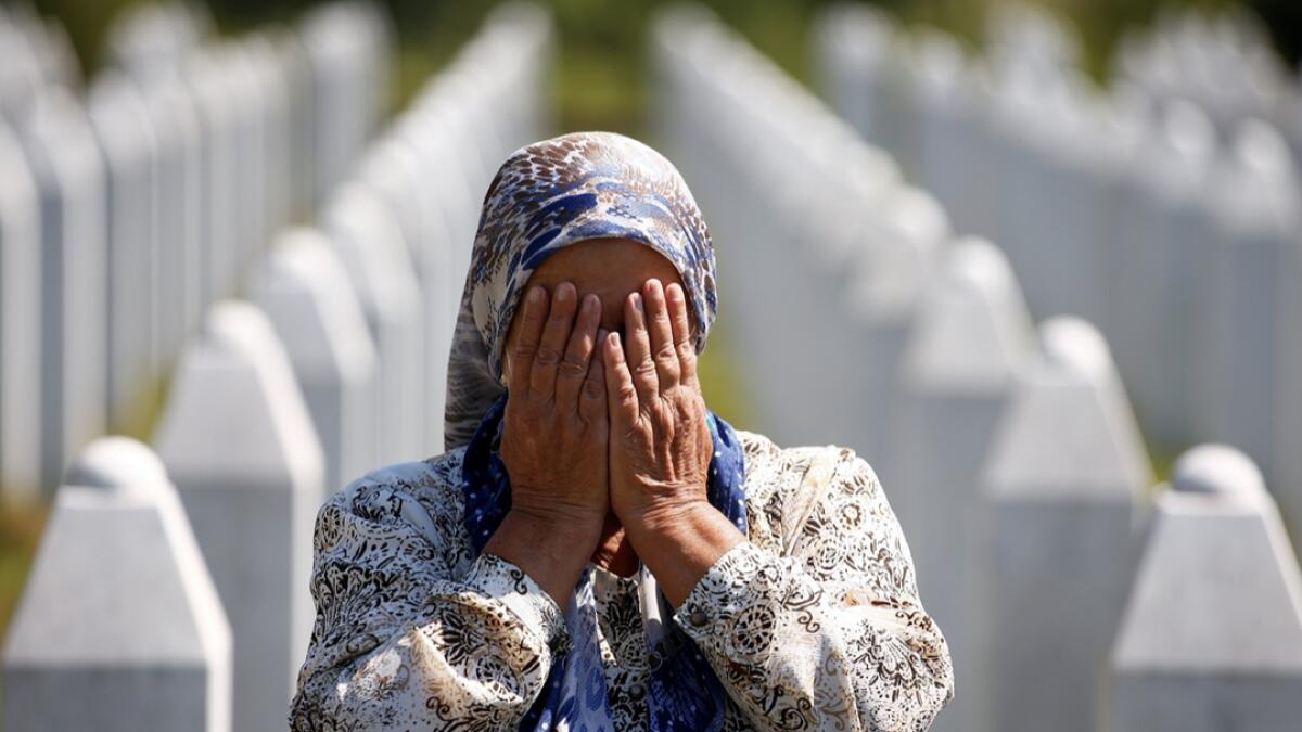 A woman prays at a graveyard, ahead of a mass funeral in Potocari near Srebrenica, Bosnia and Herzegovina July 11, 2020. Bosnia marks the 25th anniversary of the massacre of more than 8,000 Bosnian men and boys, with many relatives unable to attend due to the coronavirus disease (Covid-19) outbreak. Reuters(Research by Fakhar Ul Islam/KT)