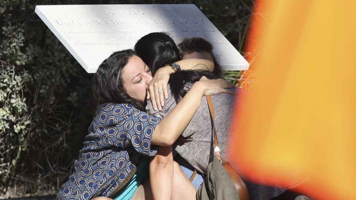 Parents of victims embrace each other near the scene of a truck attack  in Nice, southern France