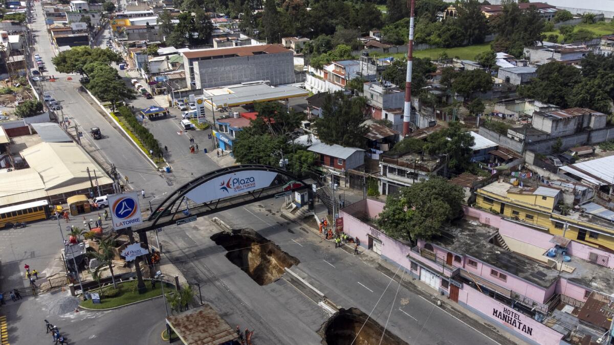 A sinkhole is exposed on the main road in Villa Nueva, Guatemala, on Sunday. — AP photos