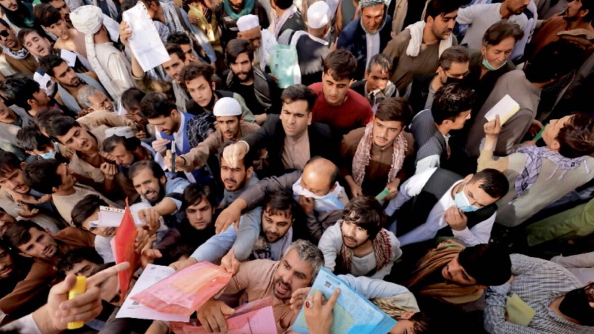 Afghans gather outside the passport office after Taliban officials announced they will start issuing passports to its citizens again. — Reuters