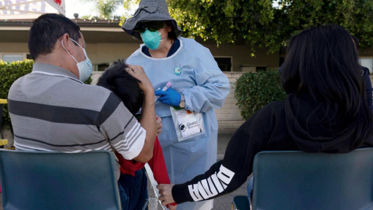 Nurse practitioner Rita Ray collects a nasal swab sample from Sebastian Hernandez, 5, for a Covid-19 test at Families Together of Orange County community health centre in Tustin, California. — AP