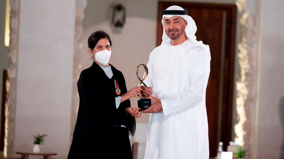 Sheikh Mohamed presents an award to Dr Fatima Al Refaei .