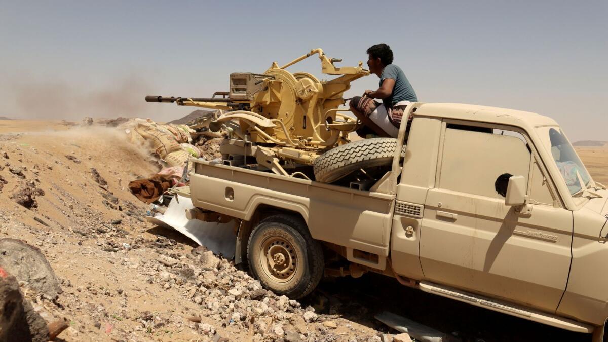 A Yemeni government fighter fires a vehicle-mounted weapon at a frontline position during fighting against Houthi fighters in Marib, Yemen on March 28, 2021.