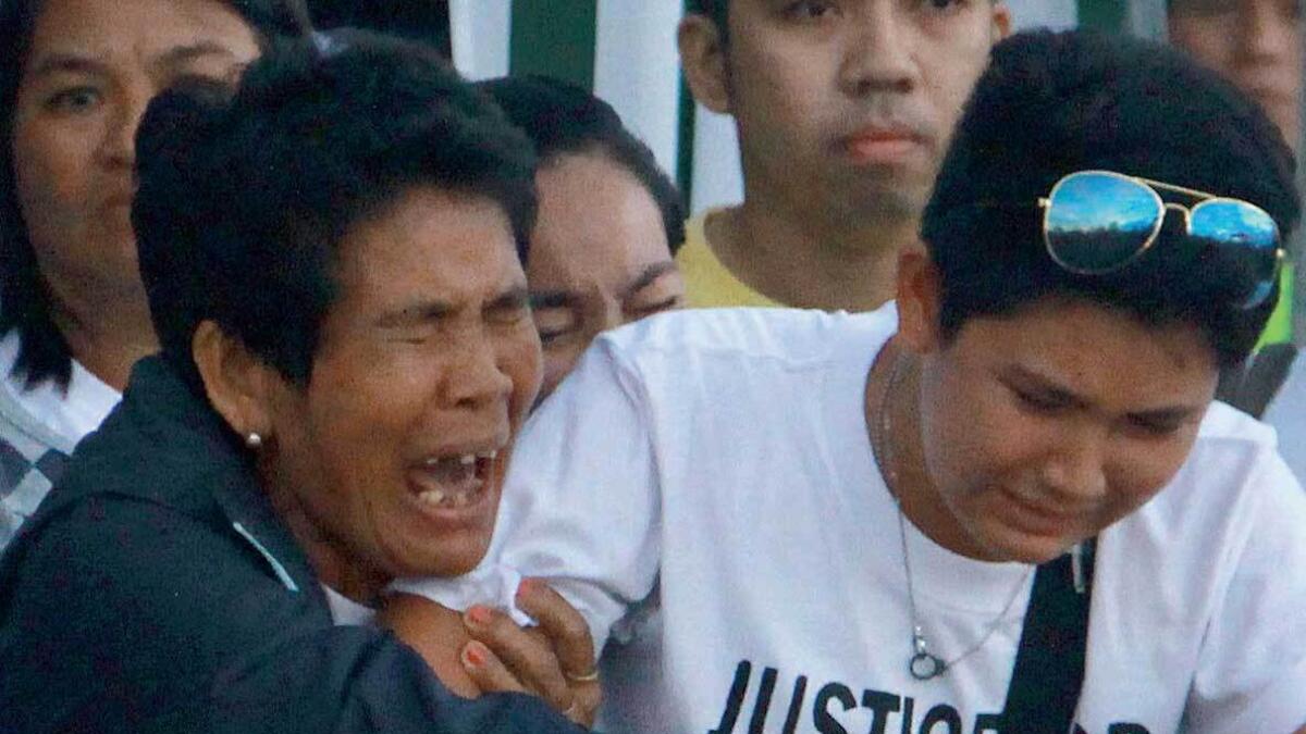 Eva, mother of Joanna Demafelis (left), cries on receiving the body of her daughter after its arrival from Manila at Iloilo International Airport in Iloilo province, central Philippines, on Saturday. — AFP