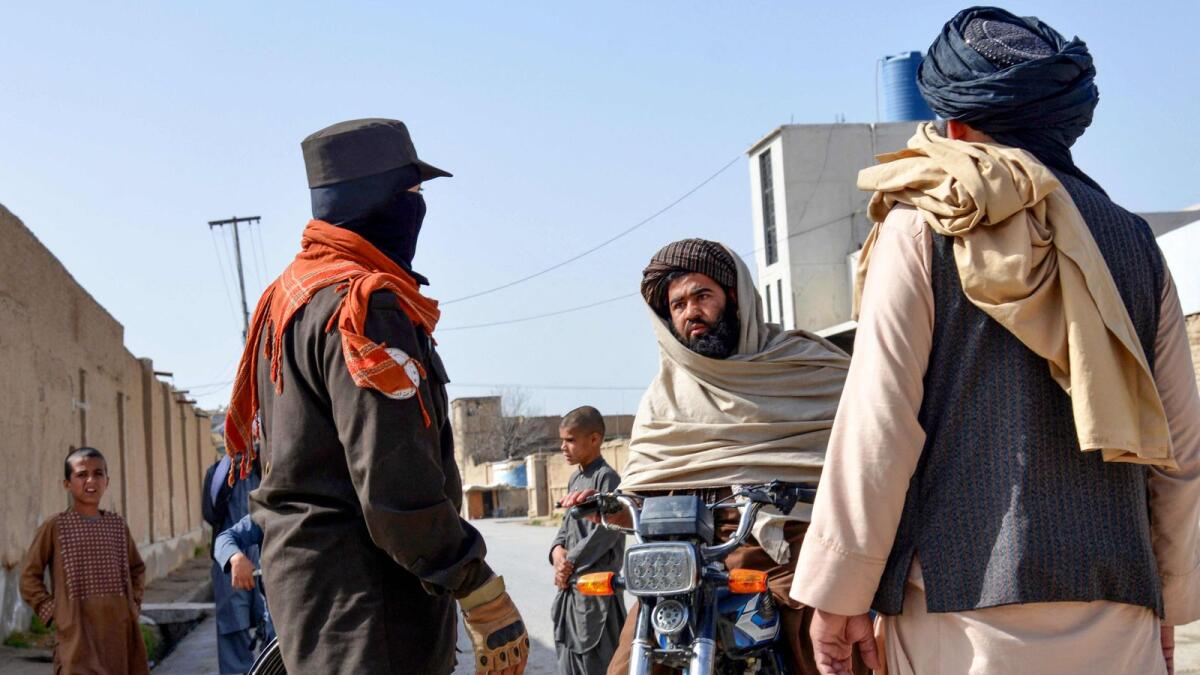An Afghan security personnel checks on a motorbike rider near the site of a suicide bomb attack in Kandahar on March 21, 2024. — Photo: AFP