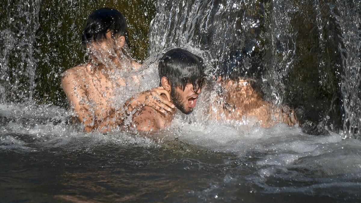 Young boys bathe in a canal during a hot day, on the outskirts of Srinagar. Photo: PTI