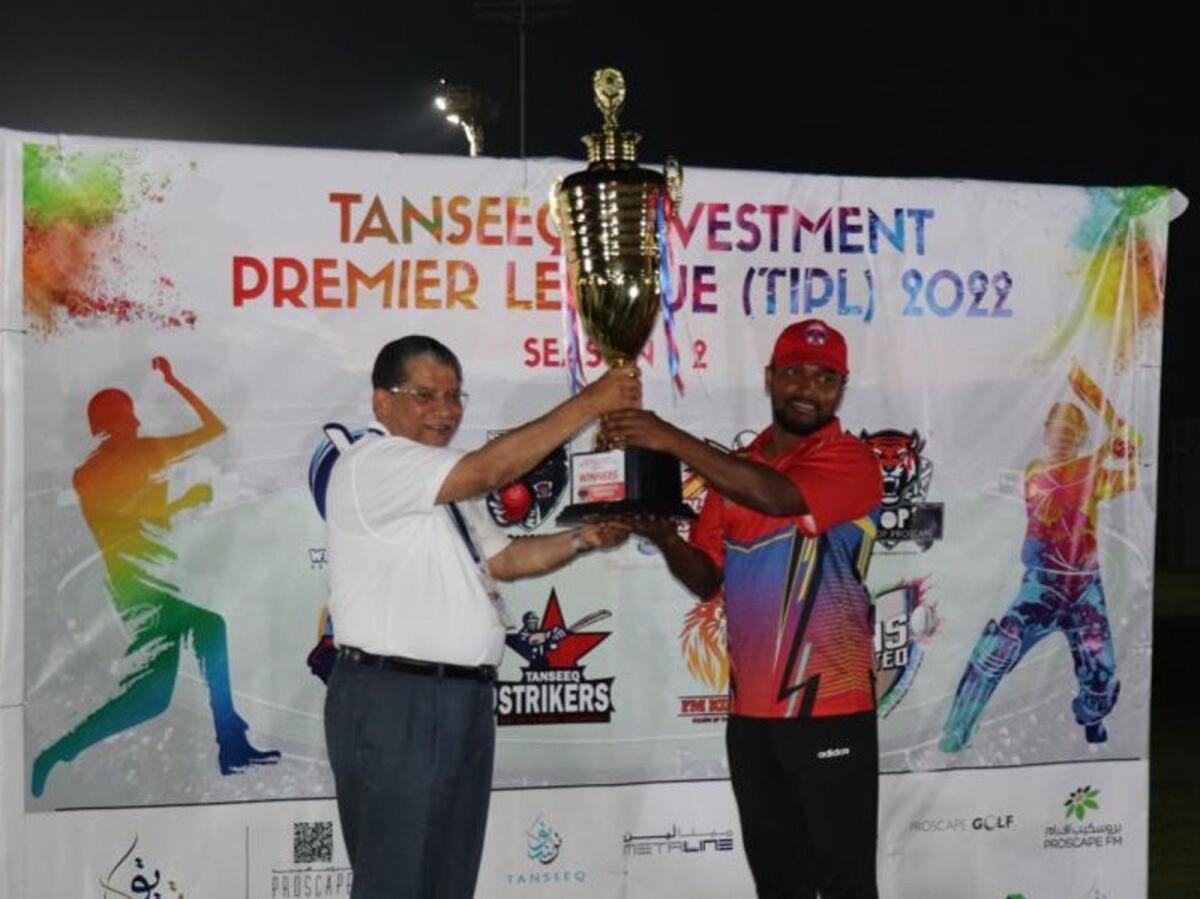 Nasser M Ahmed, Group CEO of Tanseeq Investment Group of Companies (left) presents the trophy to captain Shareef. — Supplied photo