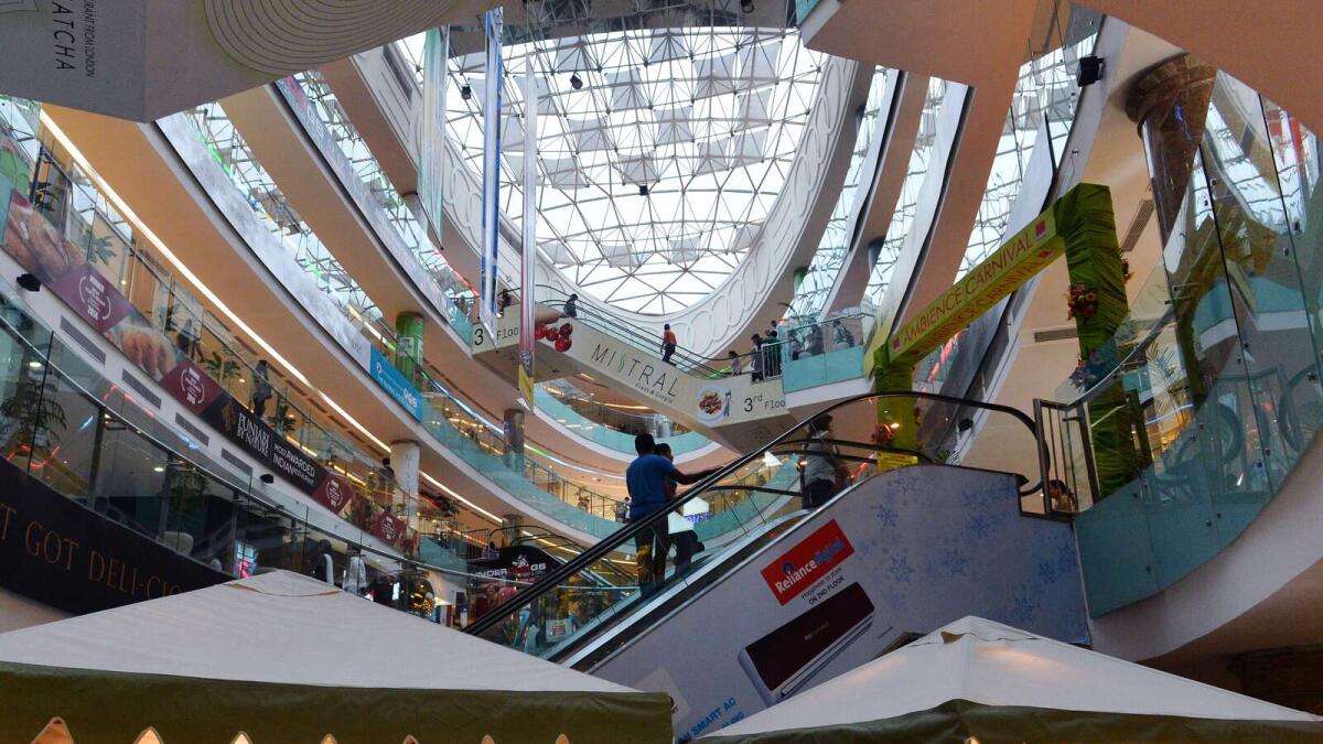 Indian shoppers walk through a mall in New Delhi.  CEBR has suggested that in the current fiscal, India’s growth is expected to be 6.8 per cent, despite rising key rates and falling global demand.  - AFP file
