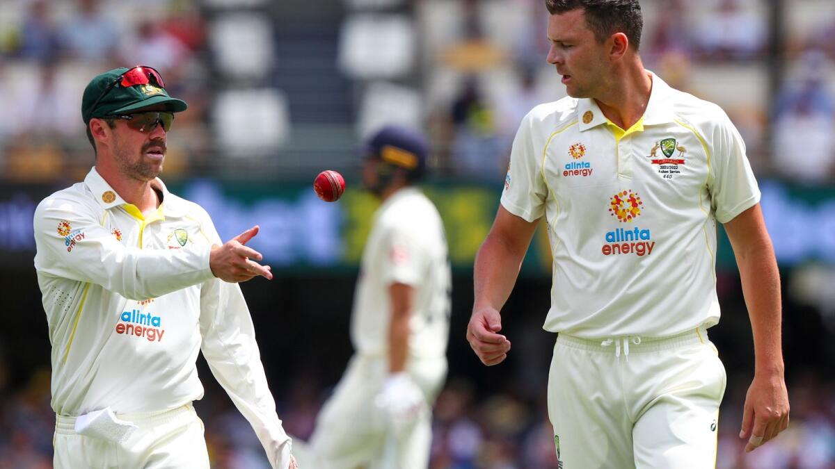 Australia's Travis Head (left) passes the ball to teammate Josh Hazlewood during day three of the first Ashes Test at the Gabba in Brisbane. (AP)