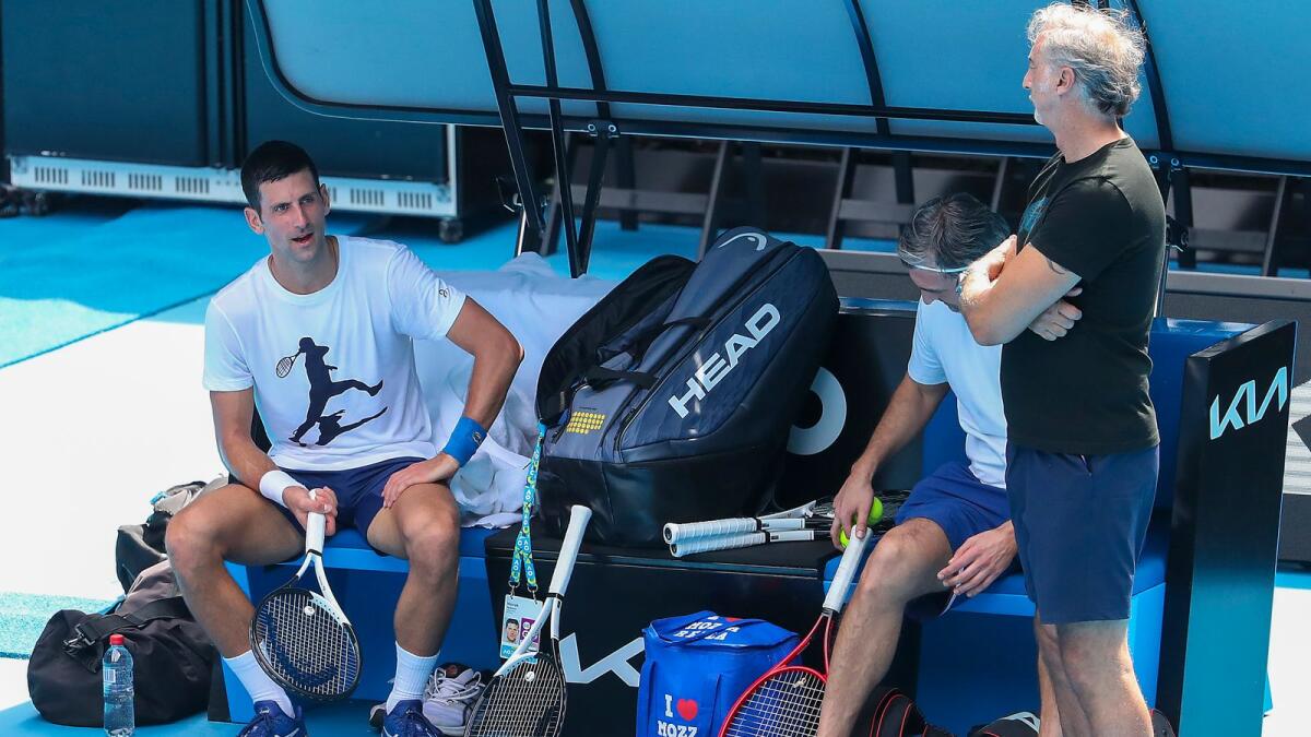 Djokovic (left) talks to a member of his coaching team during the practice session on Tuesday. (AP)