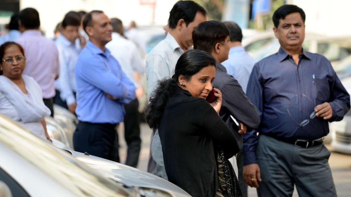 Indian office workers stand in an open area in a carpark following an earthquake in New Delhi on October 26, 2015.