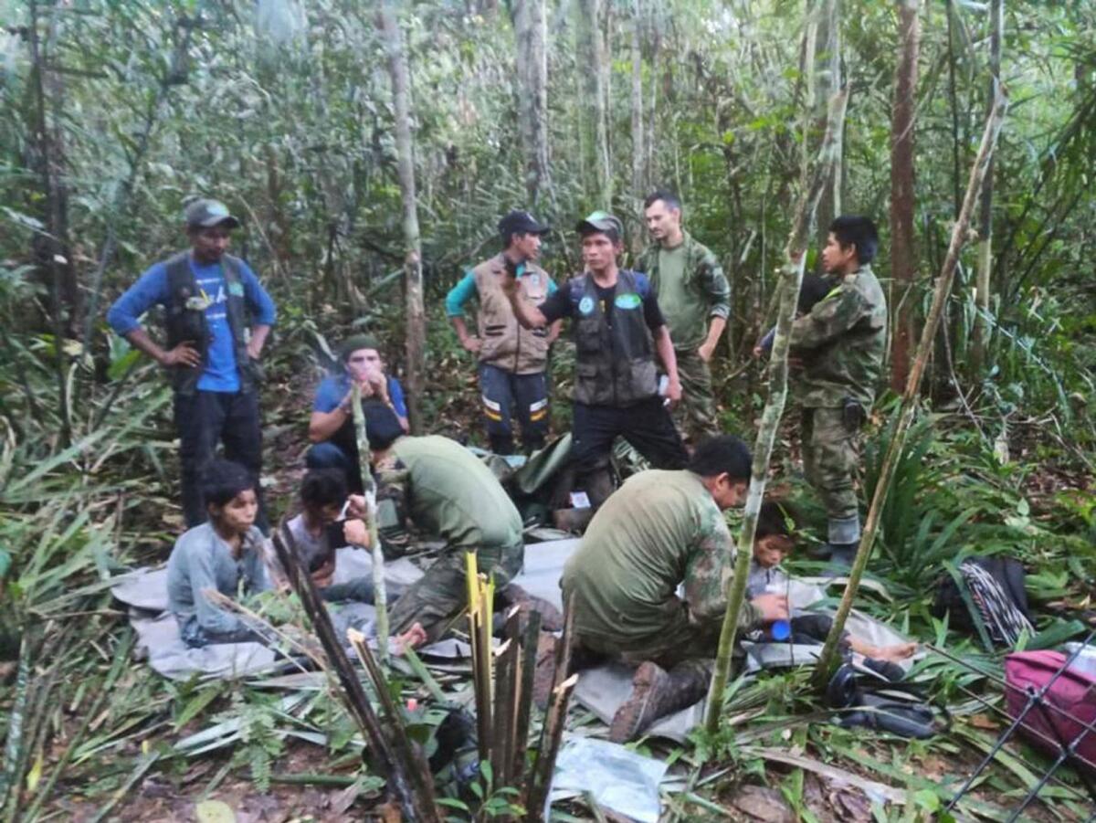 Soldiers and Indigenous men tend to the four Indigenous children who were missing after a deadly plane crash, in the Solano jungle, Caqueta state, Colombia, Friday, June 9, 2023. Photo: AFP