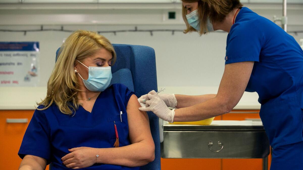 Intensive care unit nurse Efstathia Kampisiouli receives the Pfizer-BioNTech coronavirus disease (COVID-19) vaccine at Evangelismos hospital, in Athens, Greece, December 27, 2020.