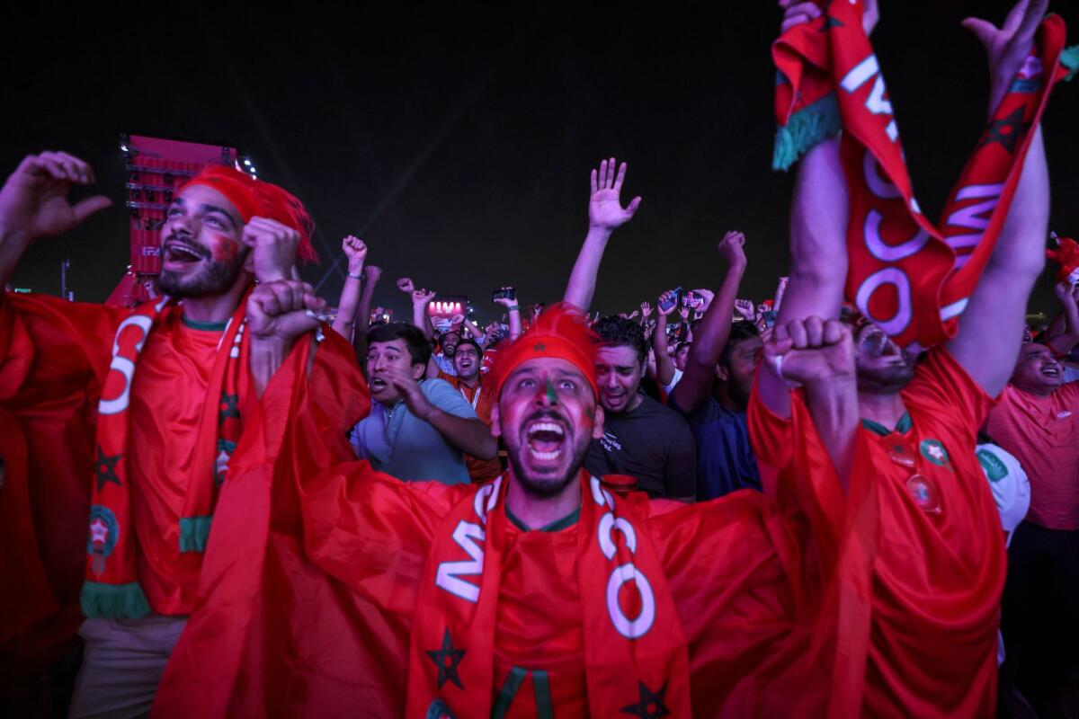 Morocco supporters celebrate at the Fifa Fan Zone in Doha after their team won against Spain. (AFP)