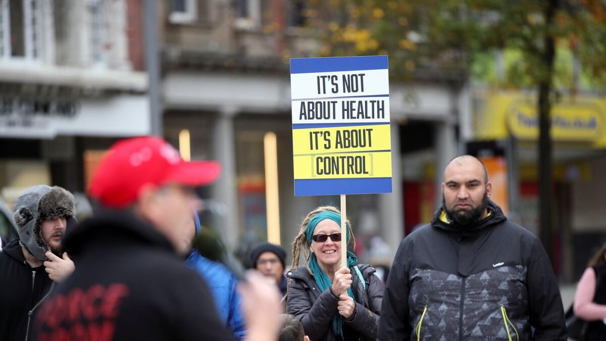 A woman holds a placard during a protest against the coronavirus disease (Covid-19) restrictions, in Nottingham, Britain, October 28, 2020. Photo: REUTERS