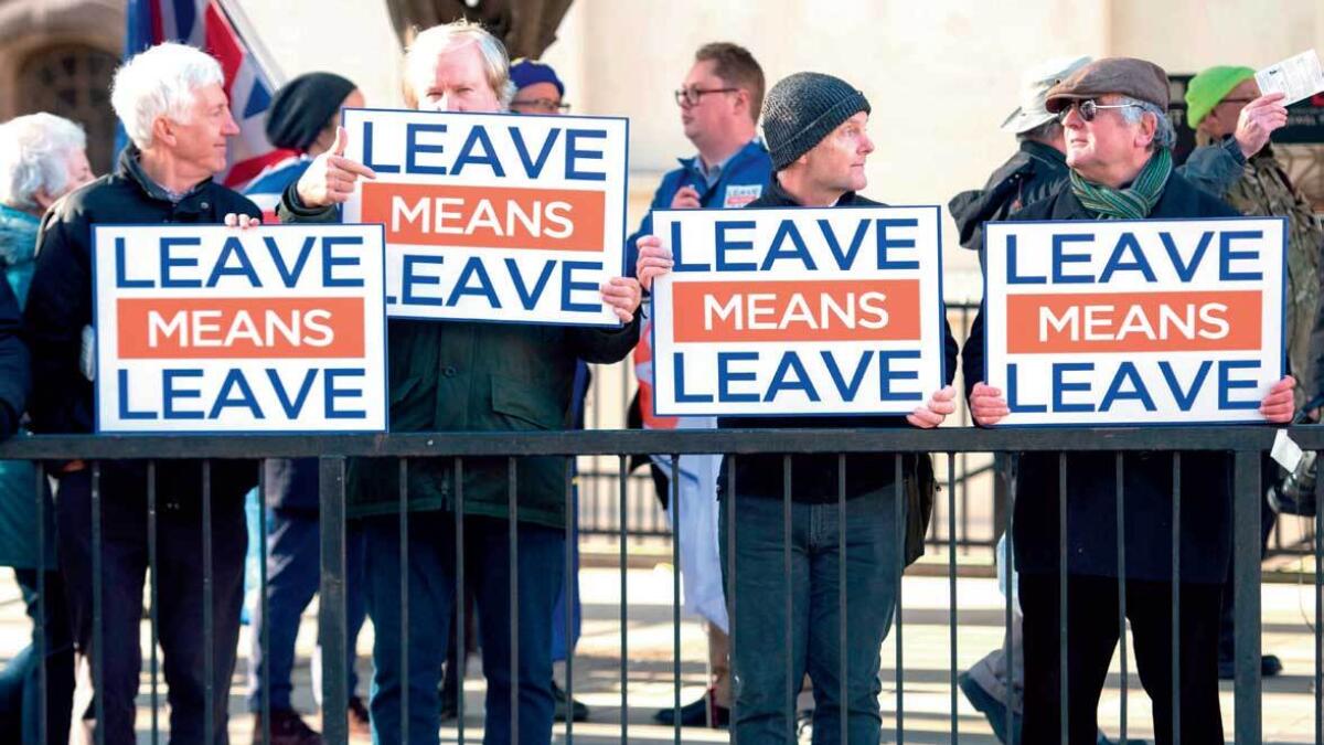 NO GOING BACK: activists hold up placards from the Leave Means Leave Pro-Brexit campaign group outside the Houses of Parliament in London. — AP