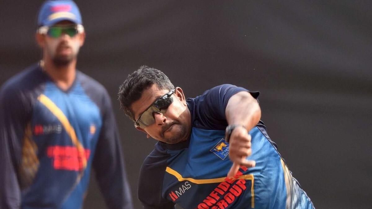 Sri Lankas Rangana Herath (R) as he bowls in the nets. 