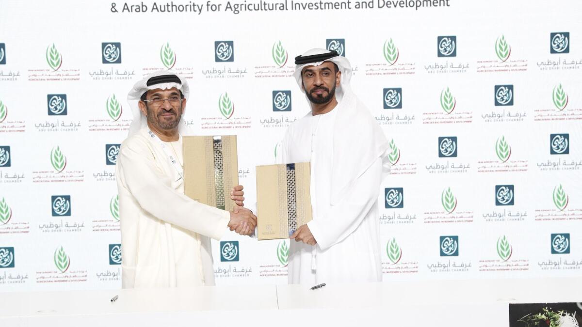 Ali Saeed bin Harmal Al Dhaheri, first vice-chairman of Abu Dhabi Chamber, and Mohamed Helal Al Mheiri, director-general of Abu Dhabi Chamber, exchanging documents after signing the deal. — Supplied photo