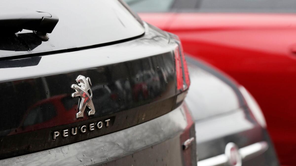 A Peugeot 3008 car is parked flanked by a 500 Fiat car in Milan. Fiat Chrysler and PSA Peugeot have signed a deal for a 50-50 merger, creating the world's fourth-largest automaker with annual sales of 8.7 million cars. -- AP