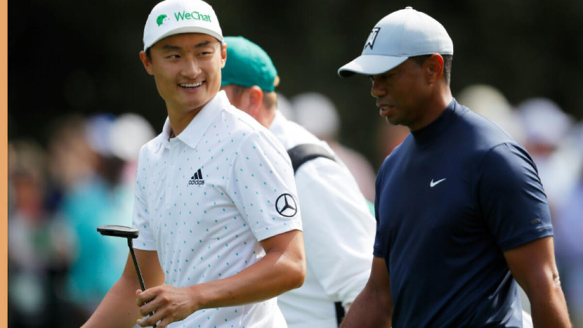 China's Li Haotong chats with Tiger Woods during the first round of the US Masters at Augusta last year. Woods went on to win his 15th major at the event. -- AFP file