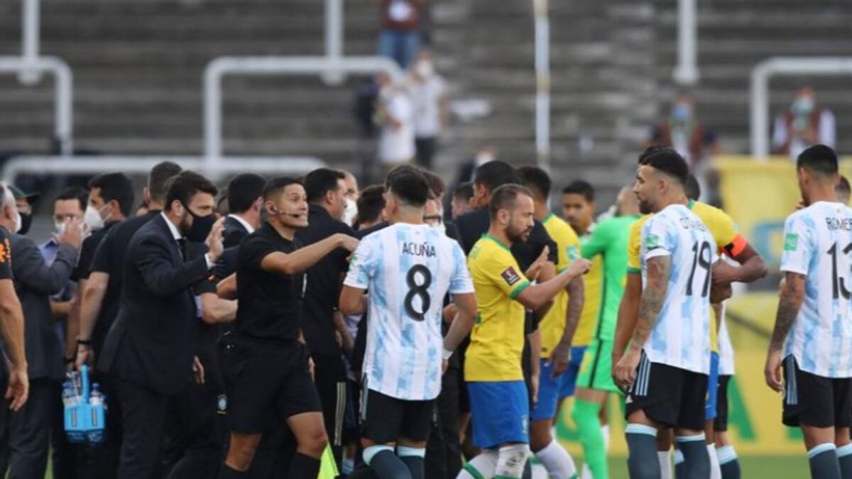 Players and officials are seen on the pitch as play is interrupted after Brazilian health officials objected to the participation of three Argentine players in the World Cup qualifying match between Brazil and Argentina. (Reuters)
