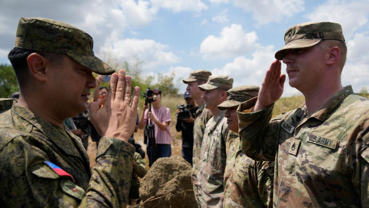 Philippine Army Artillery Regiment Commander Anthony Coronel, left, returns a salute from a US soldier during a joint military drill called Salaknib at Laur, Nueva Ecija province, northern Philippines on Friday, March 31, 2023. — AP