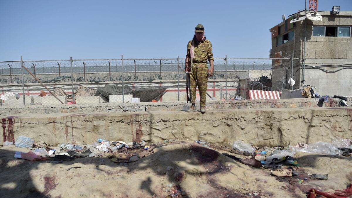 A Taliban member stands guard at the site of the August 26 bombing, which killed scores of people. Photo: AFP