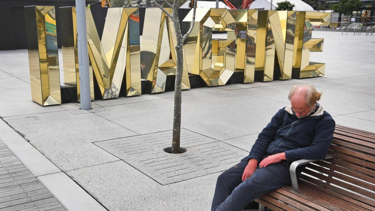 A worker takes a break in front of a giant sign that reads 'imagine' in the developing area of Barangaroo in Sydney's inner-city on 21 September, 2016. AFP