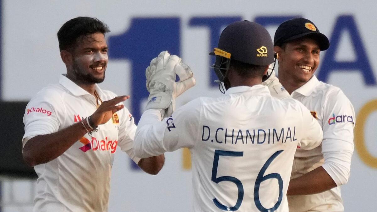 Sri Lankan off-spinner Ramesh Mendis (left) celebrates with wicketkeeper Dinesh Chandimal and Praveen Jayawickrama after dismissing West Indies batsman Roston Chase on Monday. — AP