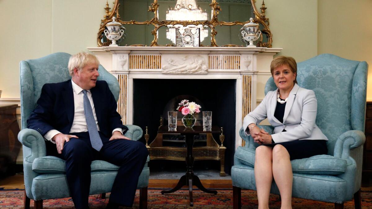 Scotland's First Minister Nicola Sturgeon, right, sits with Britain's Prime Minister Boris Johnson at Bute House in Edinburgh.