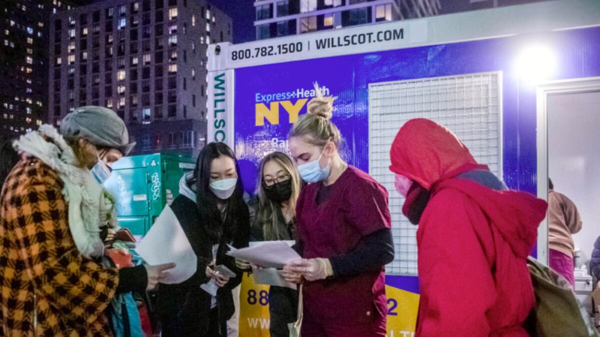 People check their rapid Covid-19 test results outside of a testing site on the Lower East Side of Manhattan. — AP