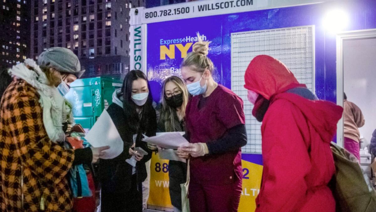 People check their rapid Covid-19 test results outside of a testing site on the Lower East Side of Manhattan. — AP