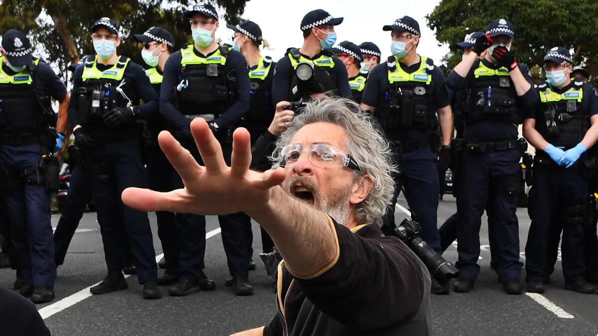 A protester confronts police during an anti-lockdown rally in Melbourne. Photo: AFP