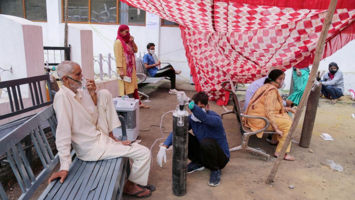 Covid-19 patients receive oxygen outside a government-run hospital in Jammu. — AP