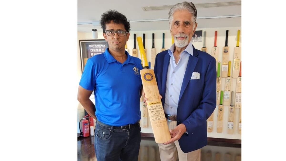 Gopal Jasapara (left) and Shyam Bhatia with a bat signed by Sunil Gavaskar. (Supplied photo)