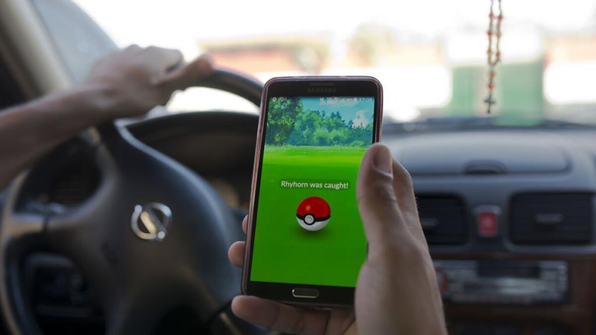 A person uses the 'Pokemon Go' mobile phone application while driving. (Illustrative picture) 