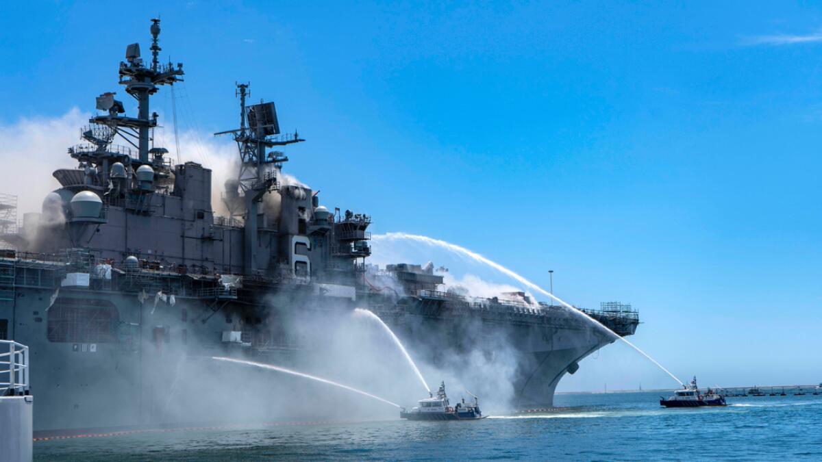 In a photo provided by the US Navy, Port of San Diego Harbor Police boats fight a fire aboard the USS Bonhomme Richard at Naval Base San Diego on Sunday, July 12, 2020. Twenty-one people suffered minor injuries in an explosion and fire on the ship, military officials said. Photo: AP
